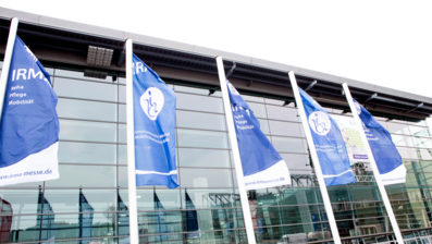 Bild der Messehalle 3 im Messezentrum Hamburg. Vor der Halle wehen Flaggen mit dem Logo der Irma Messe.